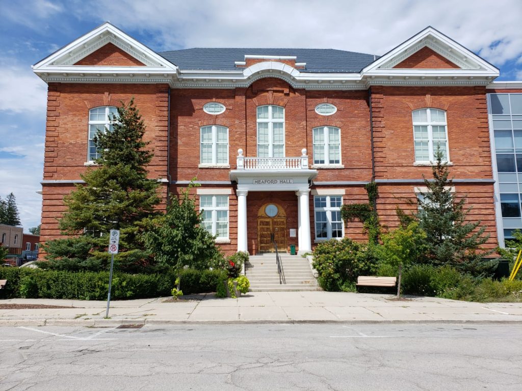 A large brick building being painted by painters in Meaford.