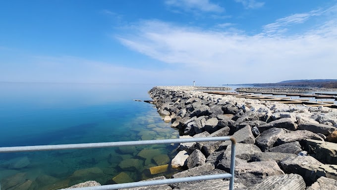 A pier with rocks and water in the background, attracting painters in Meaford.
