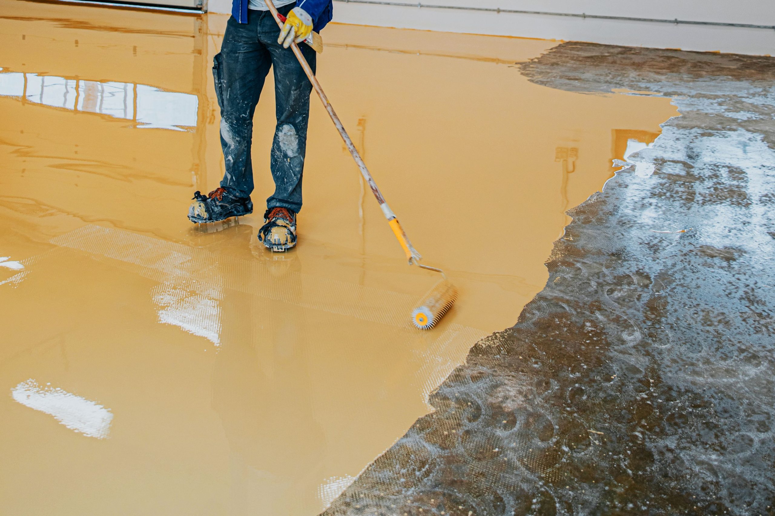 A man is painting a floor with yellow paint in Collingwood.